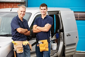 Workers In Family Business Standing Next To Van